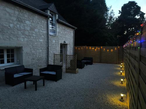un patio avec des chaises et des bougies devant un bâtiment dans l'établissement Gites les Bon' aparte gite 3, à La Chapelle-sur-Loire