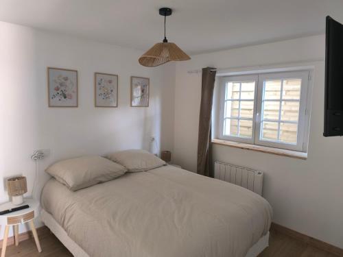 une chambre blanche avec un lit et une fenêtre dans l'établissement Gites les Bon' aparte gite 3, à La Chapelle-sur-Loire