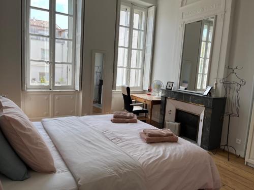 une chambre avec un lit avec deux serviettes dessus dans l'établissement Maison en centre ville avec jardin et piscine, à Bordeaux