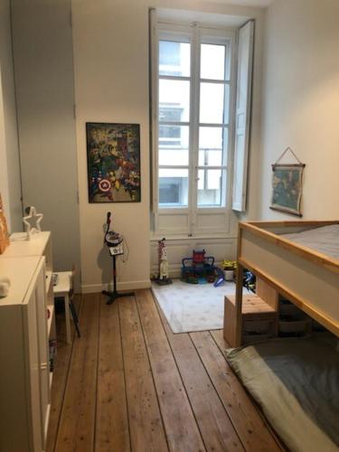 Cette chambre dispose de parquet et d'une grande fenêtre. dans l'établissement Maison en centre ville avec jardin et piscine, à Bordeaux