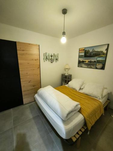 une chambre avec un grand lit avec une couverture jaune dans l'établissement La Casa d'Audenge, à Audenge