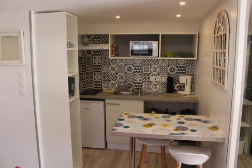 une cuisine avec une table et un comptoir dans l'établissement charmant studio plain-pied parking gratuit, à Grignon