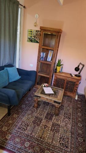 a living room with a blue couch and a coffee table at MARRAKECH פלא - PELEH - Queit place 3 km from the beach of Cesarea in Or ‘Aqīvāh