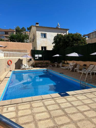 a large blue swimming pool with tables and umbrellas at Hostal San Telmo - Adults Only in Palma de Mallorca
