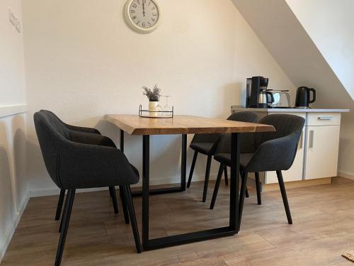 a dining room table with chairs and a clock on the wall at Ferienwohnung Lee in Bad Neuenahr-Ahrweiler