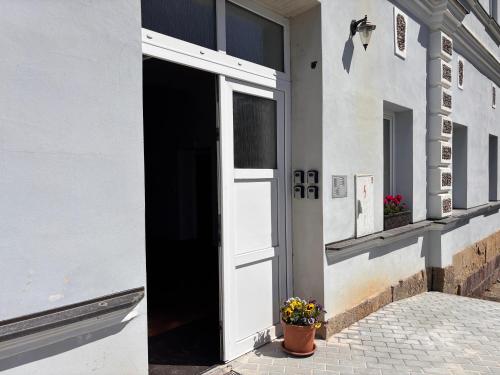 an open door of a building with a pot of flowers at Ubytování Jívka 86 in Jívka