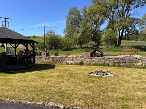 a park with a stone wall and a gazebo at Ubytování Jívka 86 in Jívka