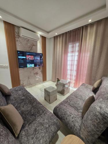 a living room with a couch and a tv at La perle bleue in La Goulette