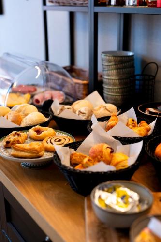 a table topped with bowls of pastries and other foods at BnB De Koepoort in Mechelen