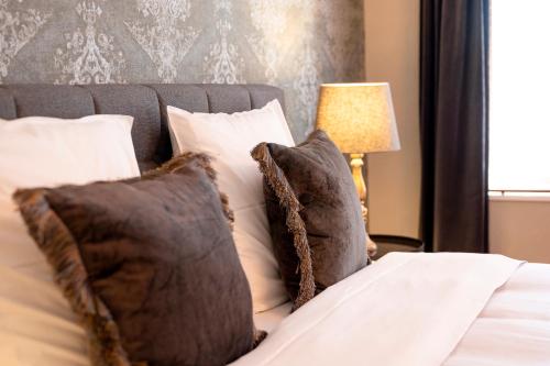 a bedroom with a bed with pillows and a lamp at BnB De Koepoort in Mechelen