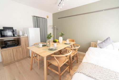 a room with a table and chairs and a bed at Alpha memory NAGOYA in Mutsunochō