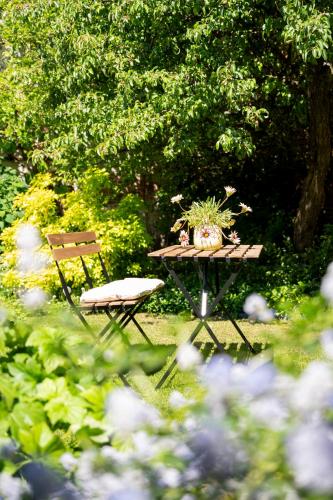 a picnic table with two potted plants and a bench at BnB De Koepoort in Mechelen