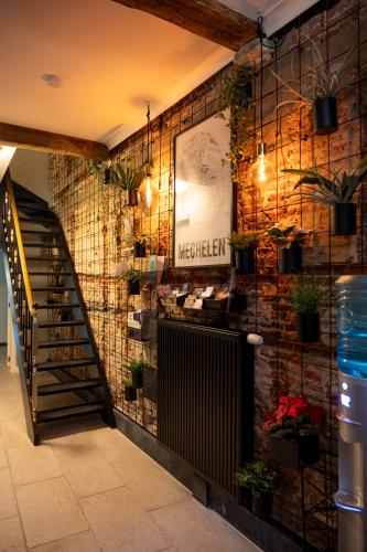a room with a staircase and plants on the wall at BnB De Koepoort in Mechelen