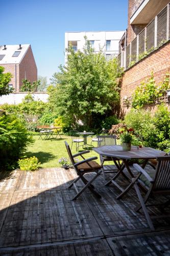 a patio with a table and chairs in a yard at BnB De Koepoort in Mechelen