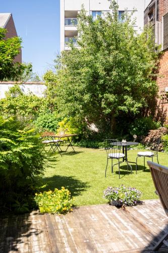 a garden with a picnic table and a table and chairs at BnB De Koepoort in Mechelen