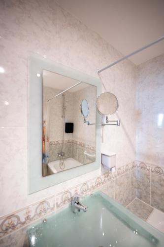 a bathroom with a tub and a mirror at Apartalux Magic Paradise in Oropesa del Mar