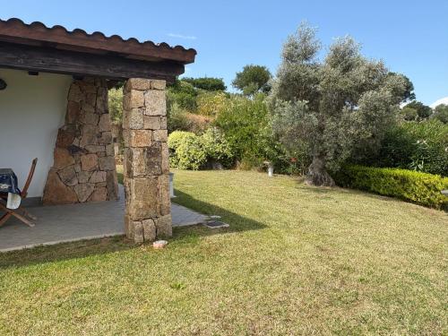 un patio con un edificio de piedra y un árbol en Villa Cugnana, en Olbia