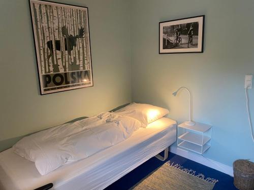 a bedroom with a bed with a lamp and a picture at Myrehøj Bed & Breakfast in Eskebjerg