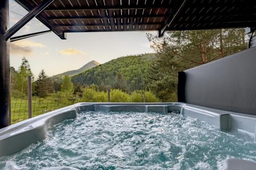 a hot tub with a view of a mountain at Buda 2 in Komjatná