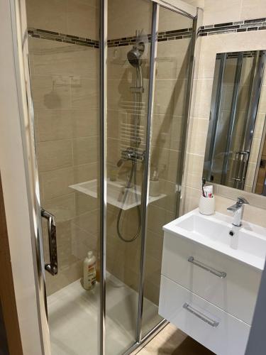 une salle de bain avec une douche en verre et un lavabo dans l'établissement L'Ostal de Jacou, à Jacou