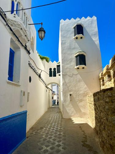 an alley with white buildings and a blue sky at Asilah Prestige -Vue Mer -Haut Standing - Piscines- Plage à 5 minute - Garage privée - Navette in Asilah