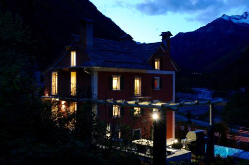 a house lit up at night with lights at MyVerzasca Resort Casa Rossa in Brione