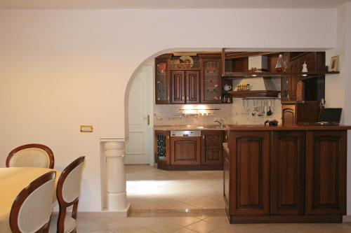 a kitchen with wooden cabinets and a table in it at PRIVILLAGE Stare - Villa & Chalet in Bohinj