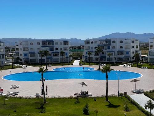 a large swimming pool with palm trees and buildings at Mirador Capo Negro in Cabo Negro