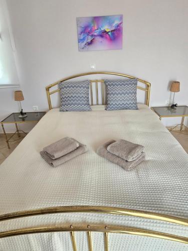 a bed with two towels on it with two tables at Villa Sea View in Chios