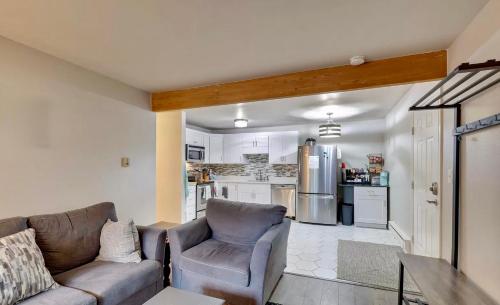 a living room with a couch and a kitchen at Renovated condo steps from Beaver Creek shuttle in Avon