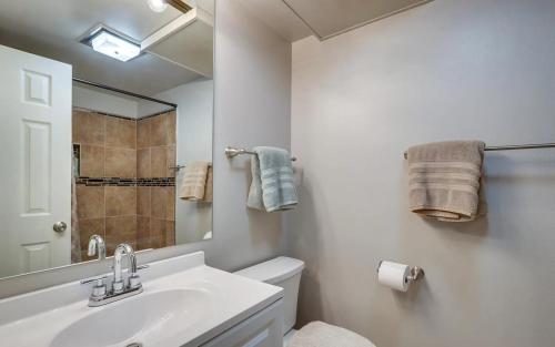 a bathroom with a sink and a toilet and a mirror at Renovated condo steps from Beaver Creek shuttle in Avon