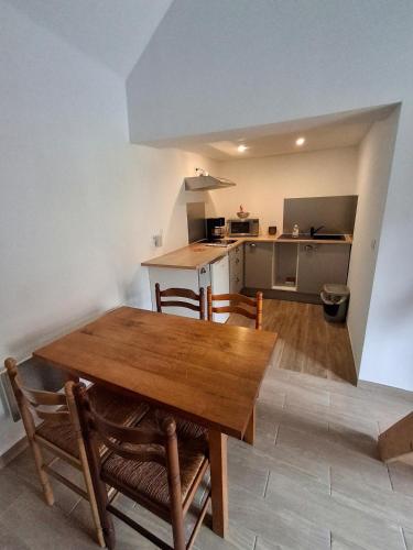 a kitchen and dining room with a wooden table and chairs at gite in Sainte-Marguerite-dʼElle