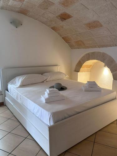 a white bed with towels on it in a room at Dimora Pugliese in Monopoli