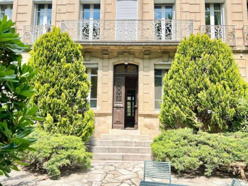 a building with a balcony and a door and trees at Bourgeois House - 16 personnes, Piscine, 6 chambres, 8 lits, 4 SDB, Centre-ville, CLIM in Salon-de-Provence