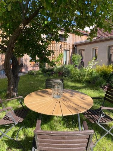 a wooden table in a yard with two chairs at Kochstedter Wohnstuben - Wohnen mit Naturbaustoffen in der Bauhausstadt Dessau in Dessau