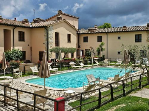 "Tuscany Hill" con giardino privato e piscina في Castagno: حمام سباحة مع كراسي ومظلات بجوار مبنى