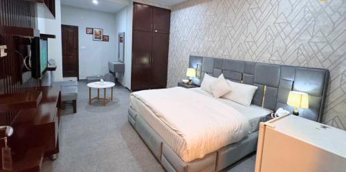 a bedroom with a large bed and a desk at Hotel The Shalimar in Lahore