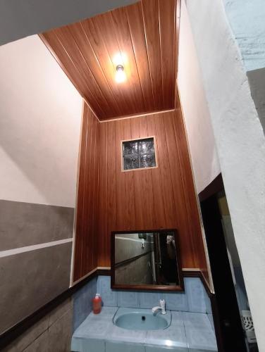 a bathroom with a sink and a mirror at Sawitri Homestay in Padangbai