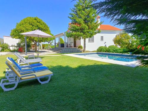 a pair of lounge chairs and an umbrella next to a pool at Casa da Gardunha in Cortiçada