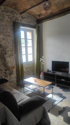 un salon avec un canapé et une table basse dans l'établissement Maison dans les Cévennes, à Bessèges