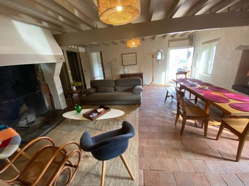 un salon avec un canapé, une table et des chaises dans l'établissement Les Nids de Galleben La Villa Landaise, à Liposthey