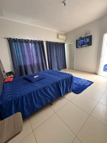 a bedroom with a blue bed and a window at Hospedaria Mantovani in Tatuí