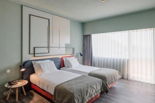 a hotel room with two beds and a window at Axis Ofir Beach Resort Hotel in Esposende