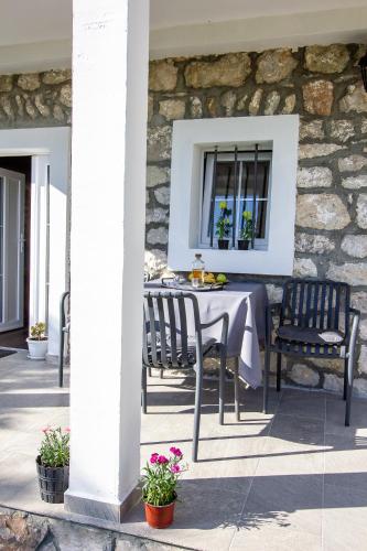 a table and chairs on a patio with a stone wall at Apartmani Stone oasis in Zupci