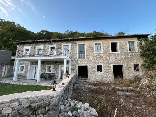 an old stone house with a stone wall at Apartmani Stone oasis in Zupci