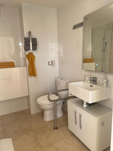 a white bathroom with a toilet and a sink at Apartmento Vista Piscina in Sant Jordi