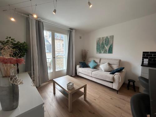 un salon avec un canapé et une table dans l'établissement Les Embruns - studio cosy plage & centre - dog friendly, à Villers-sur-Mer