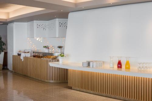 a restaurant with a counter with drinks and food at Axis Ofir Beach Resort Hotel in Esposende