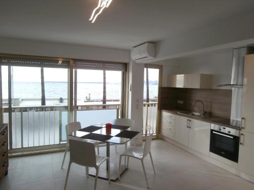 a kitchen with a table and chairs with a view of the ocean at Iberia Beach Front Sea in Juan-les-Pins