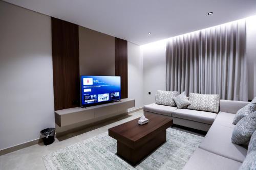 a living room with a couch and a flat screen tv at استديو ليفينج للشقق الخاصة in Al Madinah